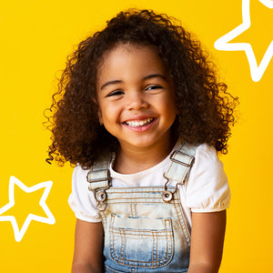 smiling young girl wearing overalls